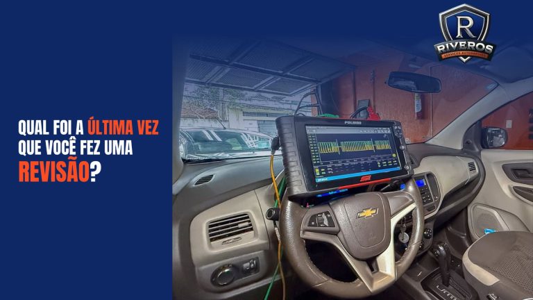 Painel de um carro Chevrolet com scanner automotivo Polibob conectado ao volante, exibindo gráficos de diagnóstico em tempo real. Ao fundo, ambiente de oficina mecânica com iluminação natural. Na parte superior da imagem, texto em destaque: “Qual foi a última vez que você fez uma revisão?”, junto ao logotipo da Riveros Serviços Automotivos